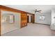 An open living space featuring wood paneling, neutral carpet, a ceiling fan, and a view into an adjacent room at 1314 Holly Dr., North Myrtle Beach, SC 29582