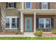 Inviting front porch with a teal door, cozy seating, and attractive landscaping at 1416 Castleberry Pl., Myrtle Beach, SC 29588