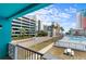View from a balcony overlooking palm trees, a large swimming pool, and the parking garage at 1600 S Ocean Blvd. # 254, Myrtle Beach, SC 29577