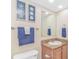 The bathroom offers a single sink, a framed mirror, coastal decor, and a toilet at 1625 S Ocean Blvd. # 1210, North Myrtle Beach, SC 29582