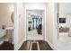 Hallway view of adjacent bedroom and bathroom, neutral colors, and dark wooden flooring at 1681 Suncrest Dr., Myrtle Beach, SC 29577