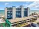 Coastal condo building with a parking garage, blue accents, palm trees, and ocean views at 1709 S Ocean Blvd. # 403, North Myrtle Beach, SC 29582