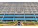 Low angle view of the condo building with rows of balconies, tropical plants, and blue accents at 1709 S Ocean Blvd. # 403, North Myrtle Beach, SC 29582