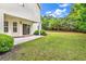 Spacious backyard featuring a sliding glass door to patio and lush green lawn at 1729 Longleaf Dr., Myrtle Beach, SC 29575
