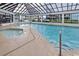 Indoor pool and hot tub area with tiled deck and natural light from multiple skylights at 200 76Th Ave. N # 301, Myrtle Beach, SC 29572