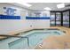 Indoor pool and hot tub area with tiled deck and natural light from multiple skylights at 200 76Th Ave. N # 301, Myrtle Beach, SC 29572