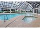 Indoor pool and hot tub area with tiled deck and natural light from multiple skylights at 200 76Th Ave. N # 301, Myrtle Beach, SC 29572