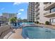 A second outdoor view of pool with building and chairs, perfect for relaxation and enjoyment at 200 76Th Ave. N # 301, Myrtle Beach, SC 29572