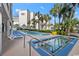 Relaxing pool area featuring comfortable lounge chairs, umbrellas, tropical landscaping, and a hot tub at 200 76Th Ave. N # 301, Myrtle Beach, SC 29572
