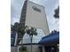 Exterior shot of the building with palm trees and blue Carolina Winds signage against a cloudy sky at 200 76Th Ave. N # 608, Myrtle Beach, SC 29572