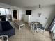Living room with tiled floors, white walls, and an adjacent dining area with seating for four at 200 76Th Ave. N # 608, Myrtle Beach, SC 29572