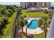 Aerial view of a community pool surrounded by lush landscaping and palm trees near the ocean at 200 Lands End Blvd. # 3015, Myrtle Beach, SC 29572