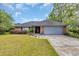 Charming brick home boasts a manicured lawn, mature trees, and an attached two-car garage at 215 Lander Dr., Conway, SC 29526