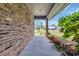 Covered brick porch features flower beds and a view of the street and neighboring houses at 215 Lander Dr., Conway, SC 29526