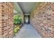 Inviting covered entry with decorative plants, brick columns, and a glimpse of the front door at 215 Lander Dr., Conway, SC 29526