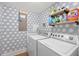 Well-organized laundry room featuring a modern washer and dryer with patterned wallpaper at 2180 Waterview Dr. # 1044, North Myrtle Beach, SC 29582