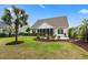 Spacious backyard with mature trees, manicured lawn, patio with seating, and grill at 235 Welcome Dr., Myrtle Beach, SC 29579
