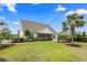 Expansive backyard with lush green lawn, mature trees, and screened-in porch, perfect for outdoor living at 235 Welcome Dr., Myrtle Beach, SC 29579