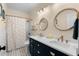 Beautiful bathroom featuring a double vanity with round mirrors, modern fixtures, and a shower-tub combination with a polka dot curtain at 235 Welcome Dr., Myrtle Beach, SC 29579