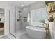 Modern bathroom showcasing a freestanding tub, glass-enclosed shower, and marble tiled walls at 235 Welcome Dr., Myrtle Beach, SC 29579
