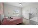 Bright bedroom with a ceiling fan, light pink walls, neutral carpet, and white trim creates a warm, inviting space at 235 Welcome Dr., Myrtle Beach, SC 29579