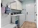 Organized laundry room with washer, dryer, storage cabinets, and a built-in bench with hooks for added convenience at 235 Welcome Dr., Myrtle Beach, SC 29579