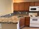 Well-lit kitchen featuring granite countertops, stainless steel sink, and mosaic tile backsplash at 238 Seabert Rd. # 238, Myrtle Beach, SC 29579