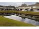 Scenic pond view with townhomes in the background, showcasing a serene community setting at 238 Seabert Rd. # 238, Myrtle Beach, SC 29579