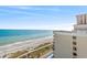 Stunning view of beach and ocean from condo balcony overlooking resort amenities and clear sky at 2701 N Ocean Blvd. # 1260, Myrtle Beach, SC 29577