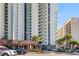An exterior view showcasing a large building with a covered entrance, palm trees, and parking at 2701 N Ocean Blvd. # 1260, Myrtle Beach, SC 29577