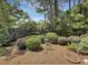 Lush backyard featuring verdant greenery, manicured hedges, and charming bird bath at 28 Torrens Pl., Pawleys Island, SC 29585
