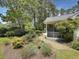 Lush backyard with brick walkway, screened-in porch, and mature trees at 28 Torrens Pl., Pawleys Island, SC 29585