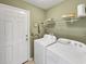 Bright laundry room with a washer, dryer, and storage shelf at 28 Torrens Pl., Pawleys Island, SC 29585