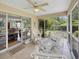 Screened porch includes white wicker furniture and a ceiling fan to enjoy the outdoors at 28 Torrens Pl., Pawleys Island, SC 29585