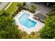 Aerial view of the sparkling community pool with ample seating and a clubhouse surrounded by mature trees at 306 River Rock Ln. # 1306, Murrells Inlet, SC 29576