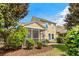 Exterior of home shows a screened in porch, lush landscaping, and manicured lawn at 306 River Rock Ln. # 1306, Murrells Inlet, SC 29576