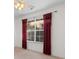Bedroom featuring natural light through a large window with decorative red curtains at 3107 Robyn Ct., Little River, SC 29566