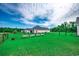 Large fenced backyard featuring a green lawn, garden beds, and mature trees for privacy at 3148 Gause Rd., Loris, SC 29569