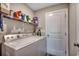 Bright laundry room featuring a white washer and dryer with overhead shelf storage and a white painted door at 3148 Gause Rd., Loris, SC 29569
