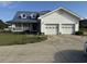 Charming white two-story home with a blue metal roof, front porch, and a two car garage at 3293 Schoolhouse Dr., Hemingway, SC 29554