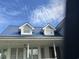 Charming two-story home exterior featuring a distinctive blue roof and white trim, complemented by dormer windows at 3293 Schoolhouse Dr., Hemingway, SC 29554