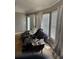 Living room featuring a large leather sofa, windows with blinds, and peeling floor at 3293 Schoolhouse Dr., Hemingway, SC 29554