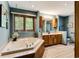 Bright bathroom boasts a large soaking tub, wood cabinets, and neutral tile flooring at 33 Brassie Dr., Carolina Shores, NC 28467