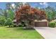 Attractive brick home featuring a well-kept lawn, mature landscaping, and an attached two-car garage with brown door at 33 Brassie Dr., Carolina Shores, NC 28467