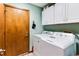 Practical laundry room boasts a modern washer and dryer, storage cabinets, and a door at 33 Brassie Dr., Carolina Shores, NC 28467
