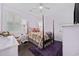 Cozy bedroom with a four-poster bed, floral bedding, hardwood floors, and ample natural light at 3381 Pampas Dr., Myrtle Beach, SC 29577