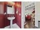 Stylish powder room with a pedestal sink, striped walls, and access to the living area at 3381 Pampas Dr., Myrtle Beach, SC 29577