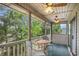 Inviting balcony space with a table and chairs, offering views of the surrounding trees and lake at 342 Pinehurst Ln. # 12J, Pawleys Island, SC 29585