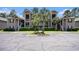 Exterior view of the condo building featuring parking and well-manicured landscaping at 342 Pinehurst Ln. # 12J, Pawleys Island, SC 29585
