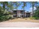 Exterior view of a condo building with multiple screened-in patios, partially obstructed by mature trees at 342 Pinehurst Ln. # 12J, Pawleys Island, SC 29585